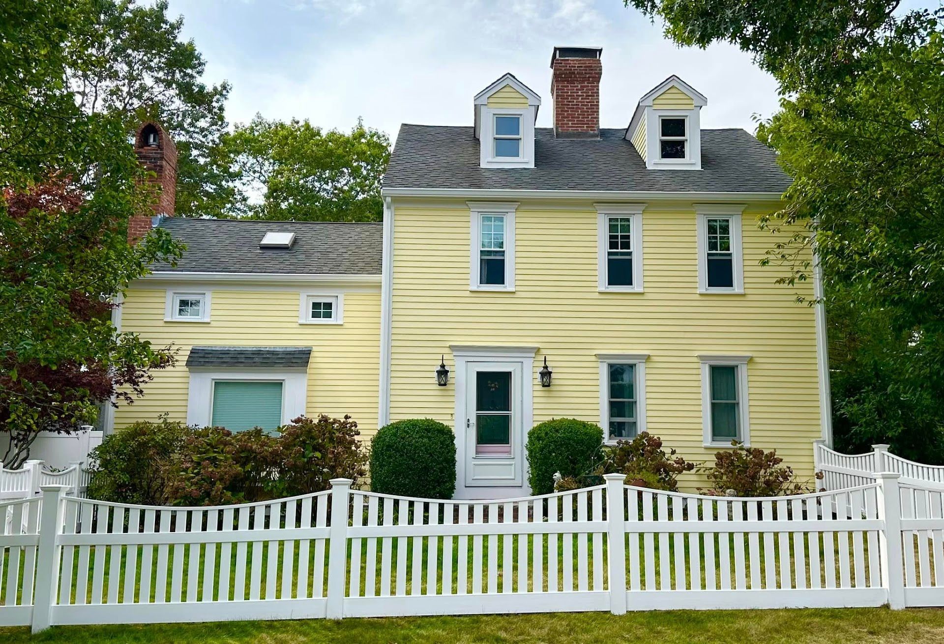 Nelson Painting is a local house-painting business that provides exterior house painting, shown here after a colonial clapboard yellow project