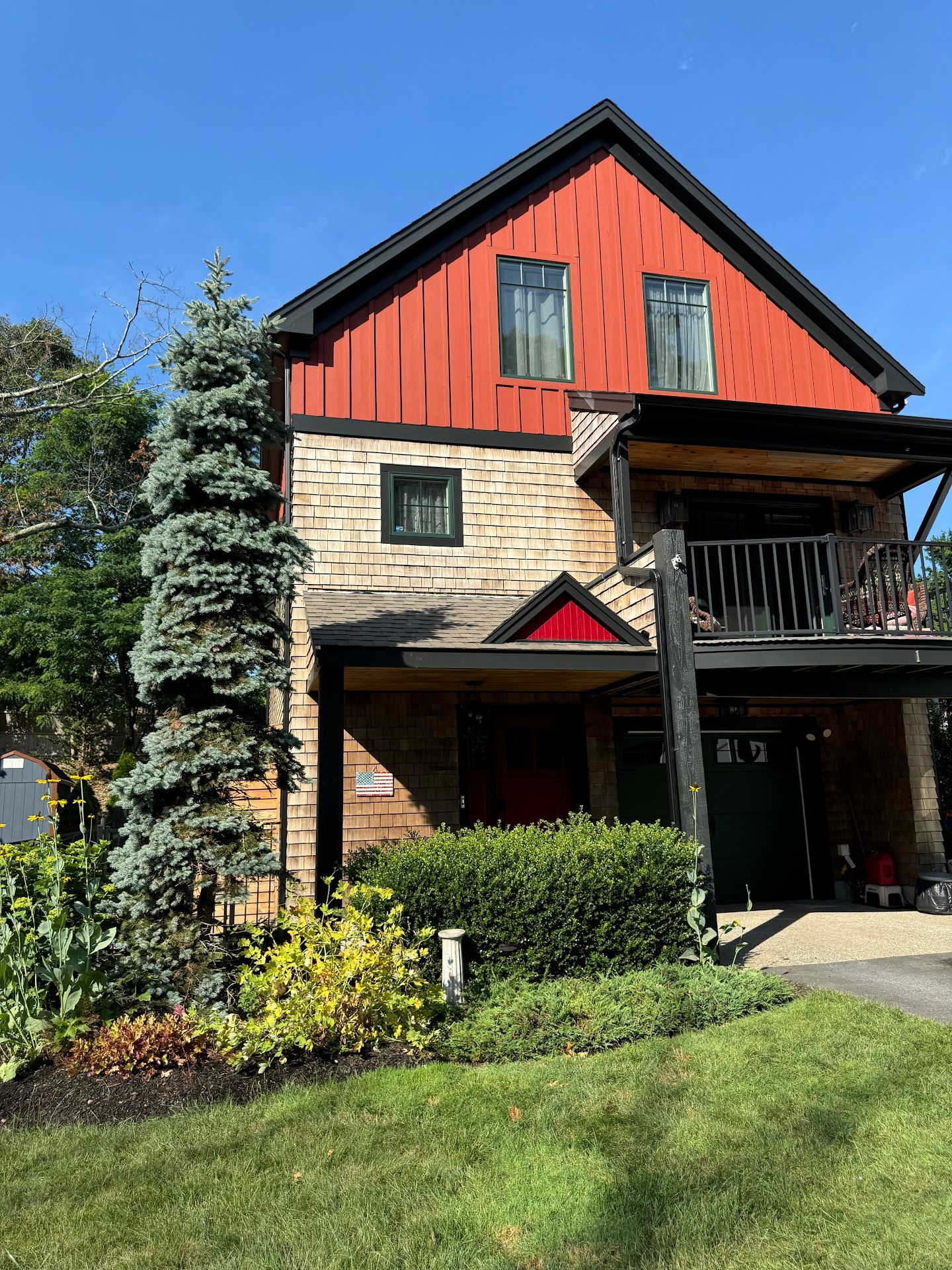 Nelson Painting is a painting contractor that provides exterior house painting, shown here after a siding board and batten red project
