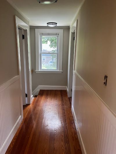 Nelson Painting is a family-owned painting business that provides interior painting, shown here after a hallway beige walls white wainscoting project