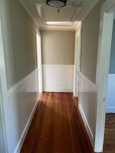 Nelson Painting is a painting company that provides interior painting, shown here after a hallway green walls white wainscoting project