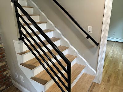 Nelson Painting is a local house-painting business that provides interior painting, shown here after a staircase white risers black railing project