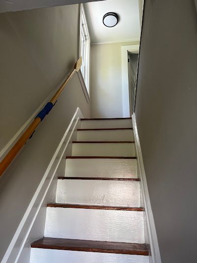 Nelson Painting is a third-generation painting business that provides interior painting, shown here after a staircase white risers stained treads handrail project