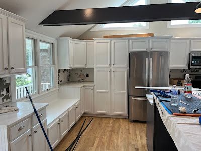 Nelson Painting is a family-owned painting business that provides cabinet refinishing and kitchen cabinet painting, shown here after a kitchen white cabinets project