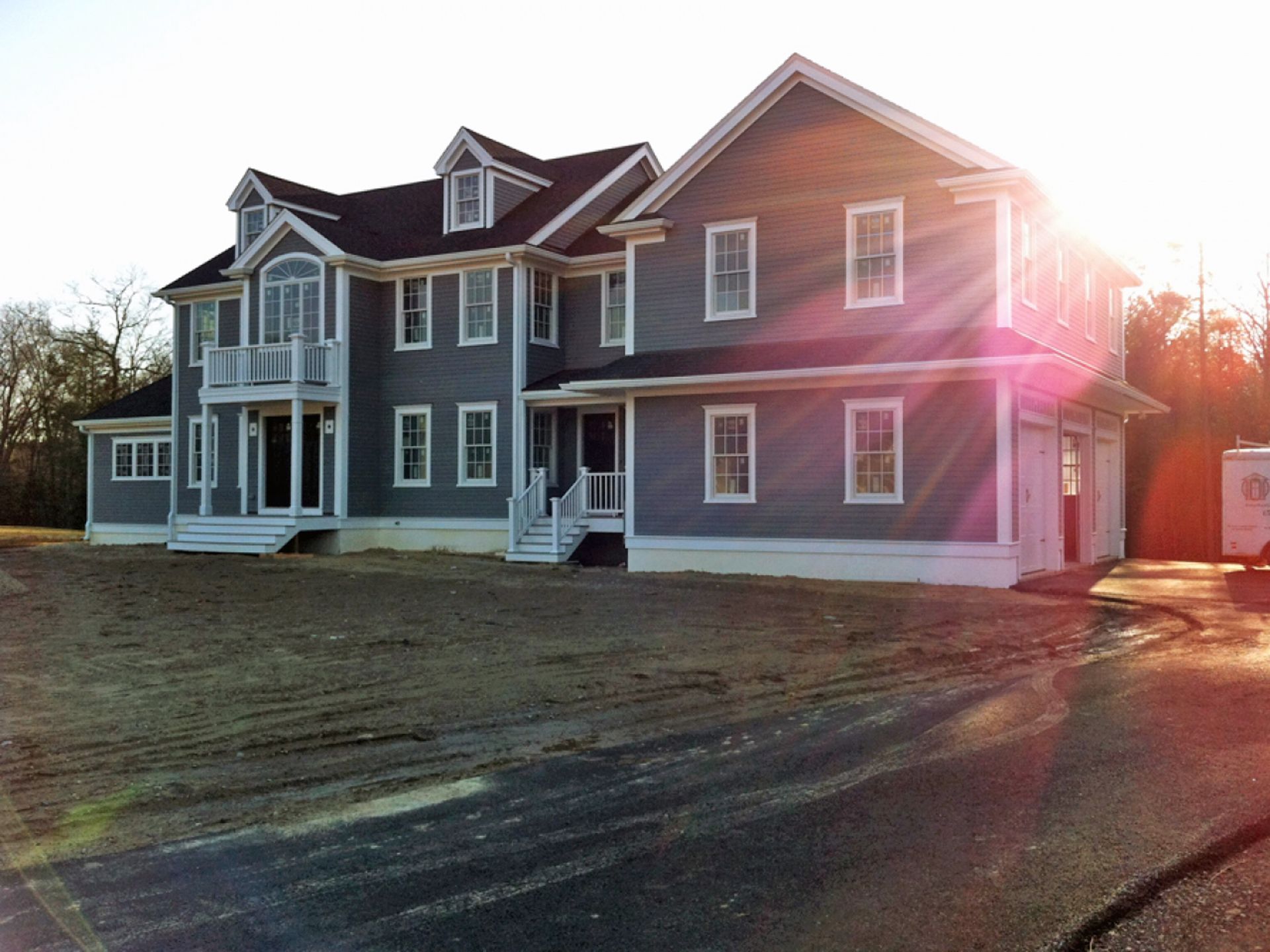 Nelson Painting is a local house-painting business that provides exterior house painting, shown here after a colonial gray siding white trim project