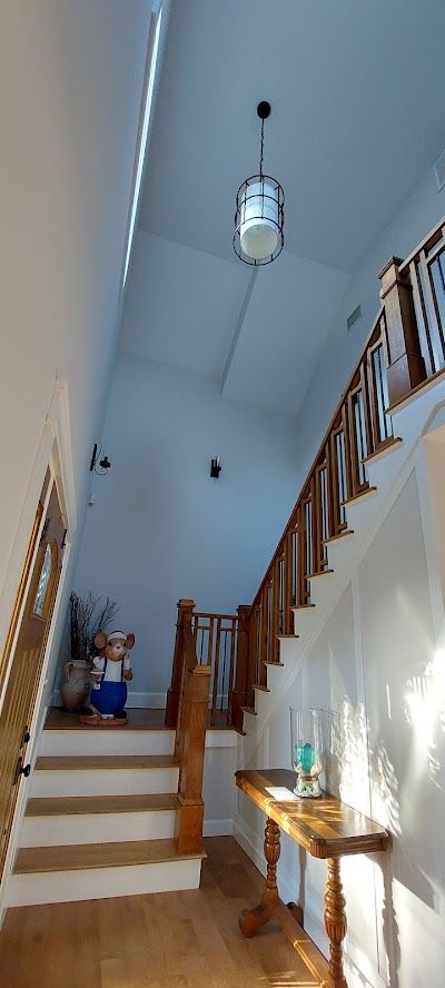 Nelson Painting is a local house-painting business that provides interior painting, shown here after a foyer staircase white walls vaulted project
