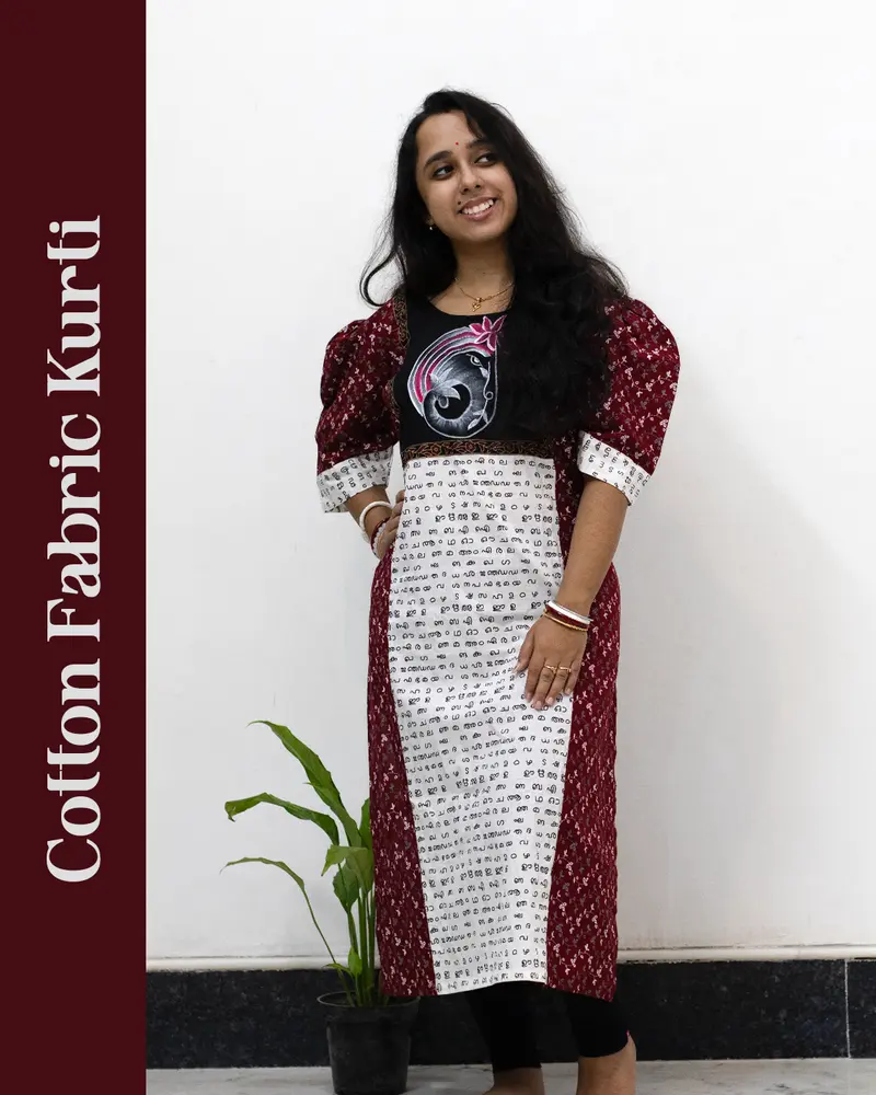 Woman wearing cotton kurti with Malayalam character print, puff sleeves, side pocket, thread work, and hand-painted yoke design – SutiSaaj.