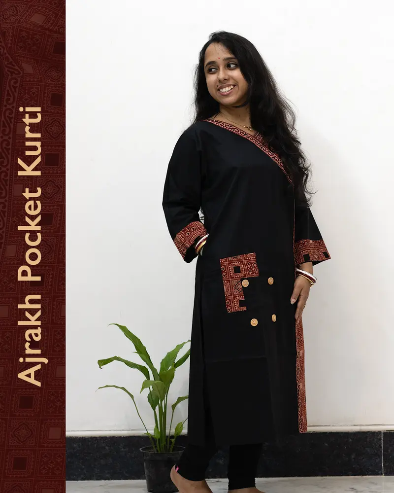 Woman wearing black pure cotton Angrakha kurti with Ajrakh block print, designed cuffs, side pocket, and decorative front buttoned pocket – SutiSaaj.