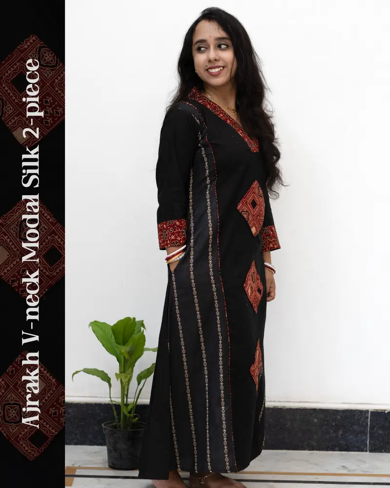 Woman wearing black Ajrakh V-neck 2-piece modal silk kurti with cuff design, side pockets, front panel Ajrakh motifs, and ethnic hand-block print detailing – SutiSaaj.