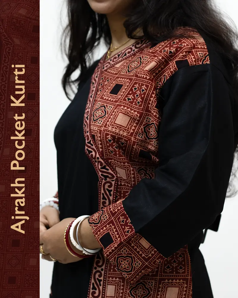 Woman wearing black pure cotton Angrakha kurti with Ajrakh block print, designed cuffs, side pocket, and decorative front buttoned pocket – SutiSaaj.