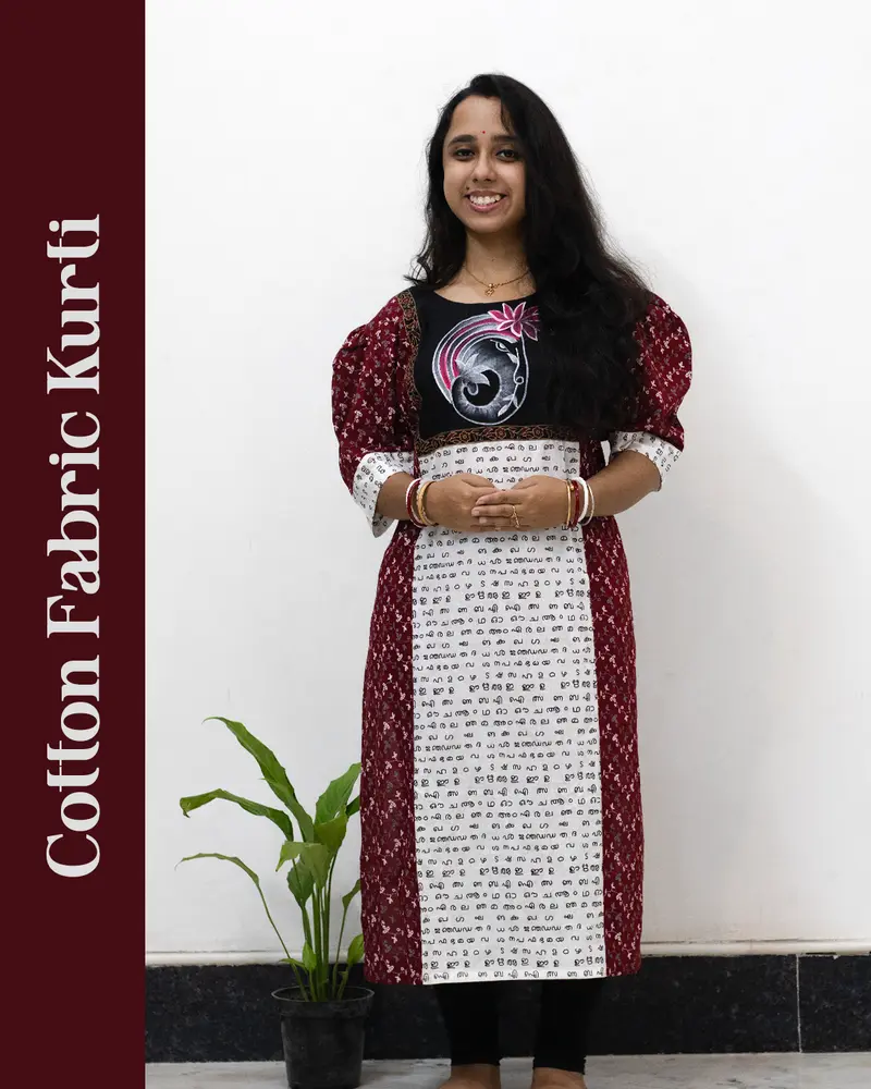 Woman wearing cotton kurti with Malayalam character print, puff sleeves, side pocket, thread work, and hand-painted yoke design – SutiSaaj.