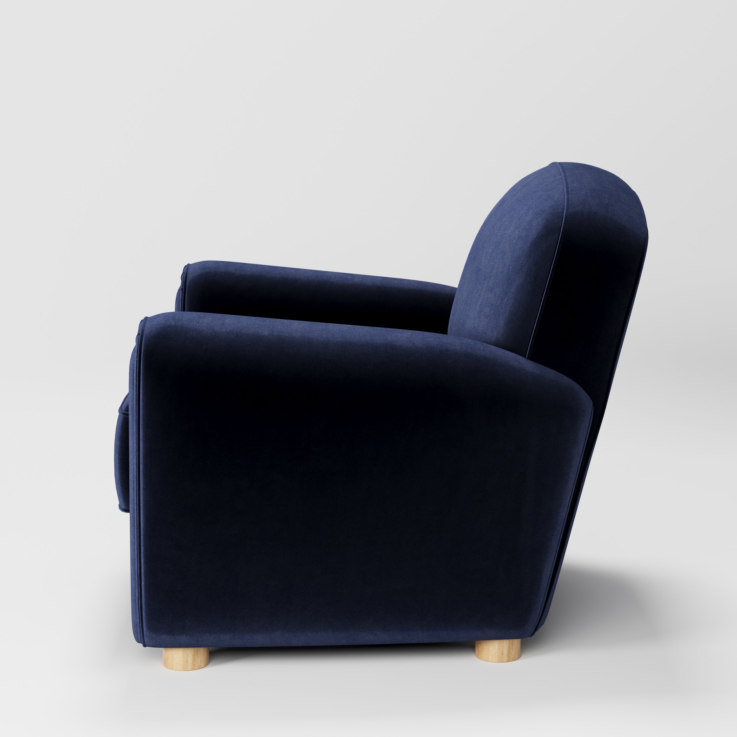 Fergus armchair in Noss Velvet Navy shown in side profile displaying proportions and overall silhouette.