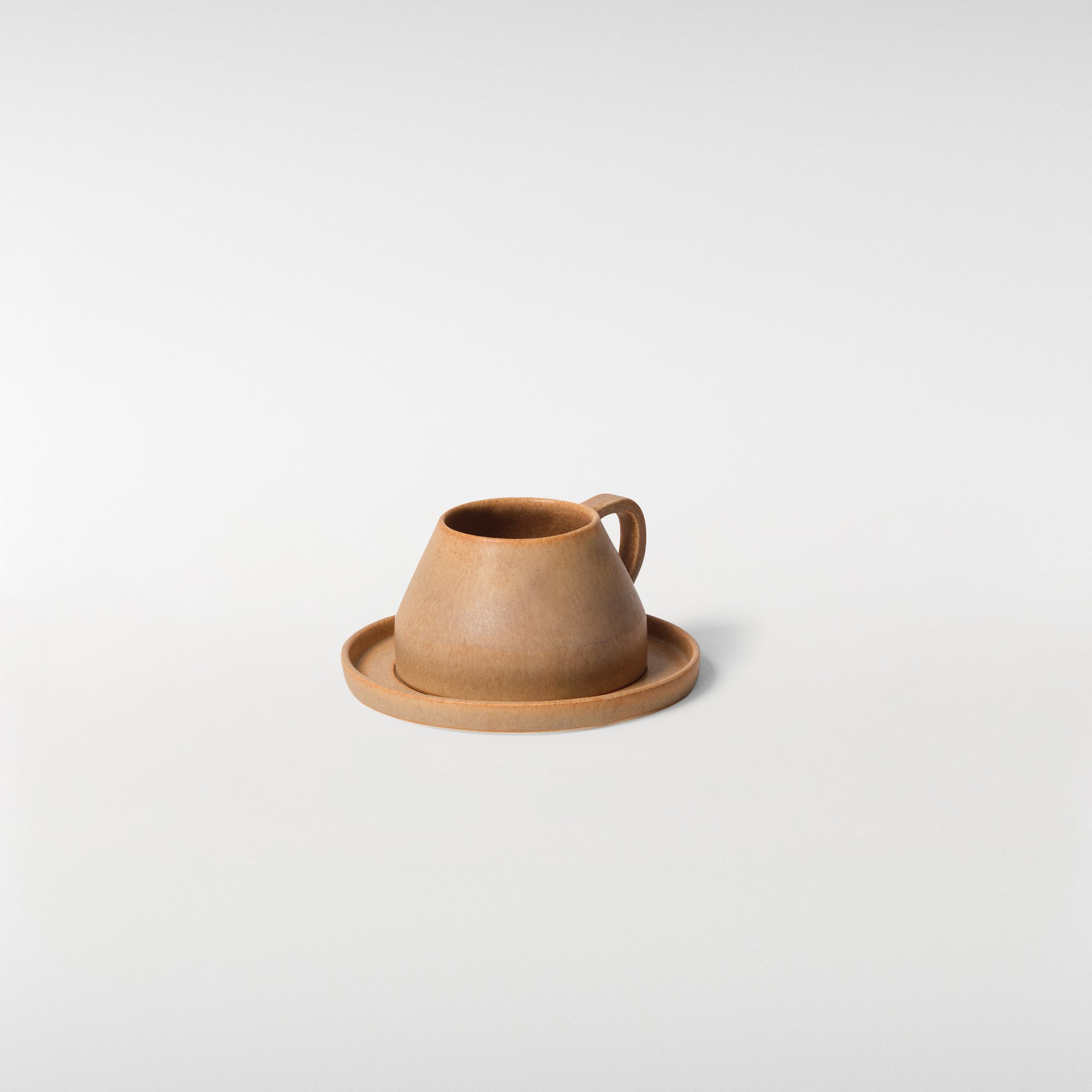 Chamfer Honey glazed ceramic cup and saucer set, three-quarter angle highlighting faceted form, handle detail and subtle surface texture