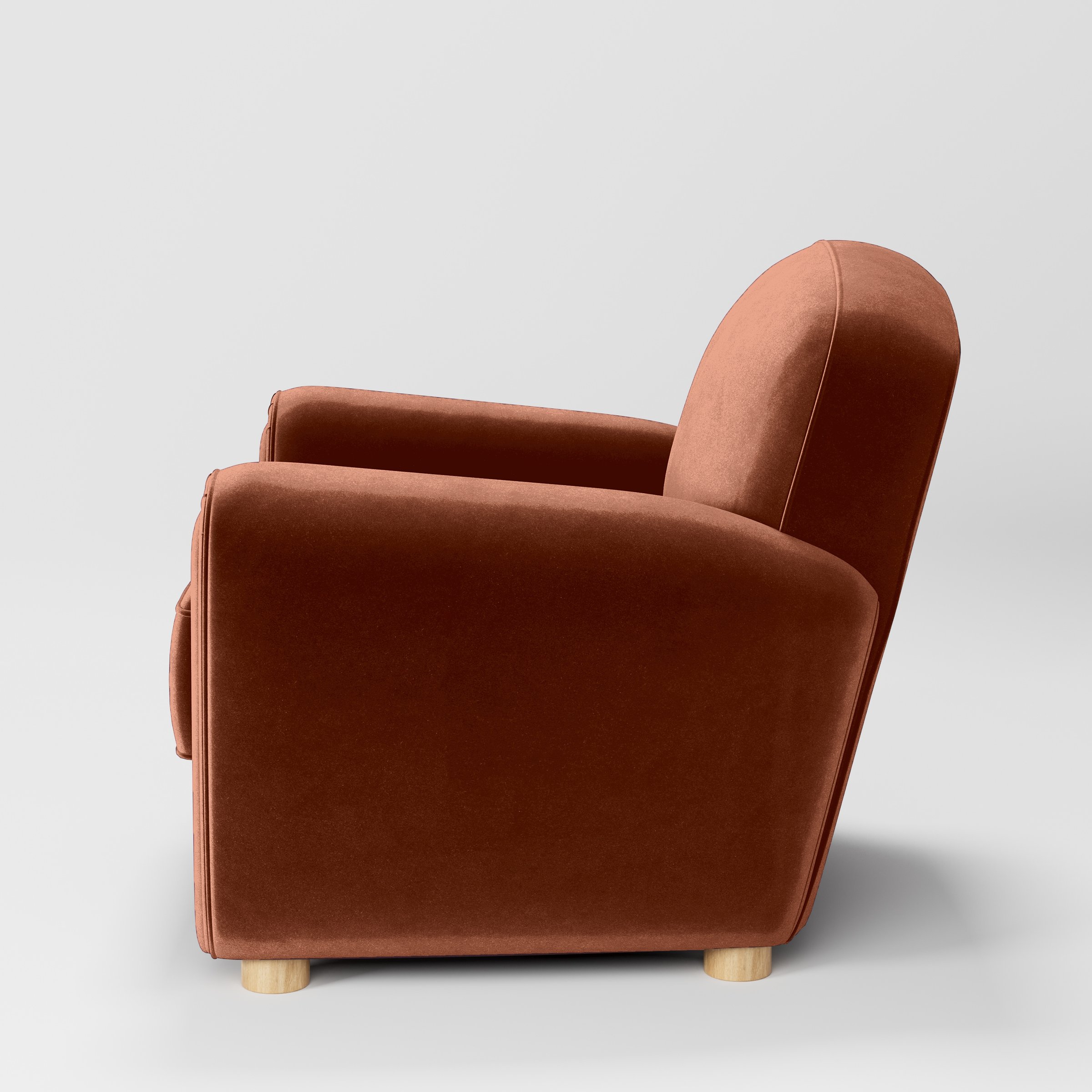 Side view of the Fergus armchair upholstered in Plush EasyClean Velvet in Apricot.