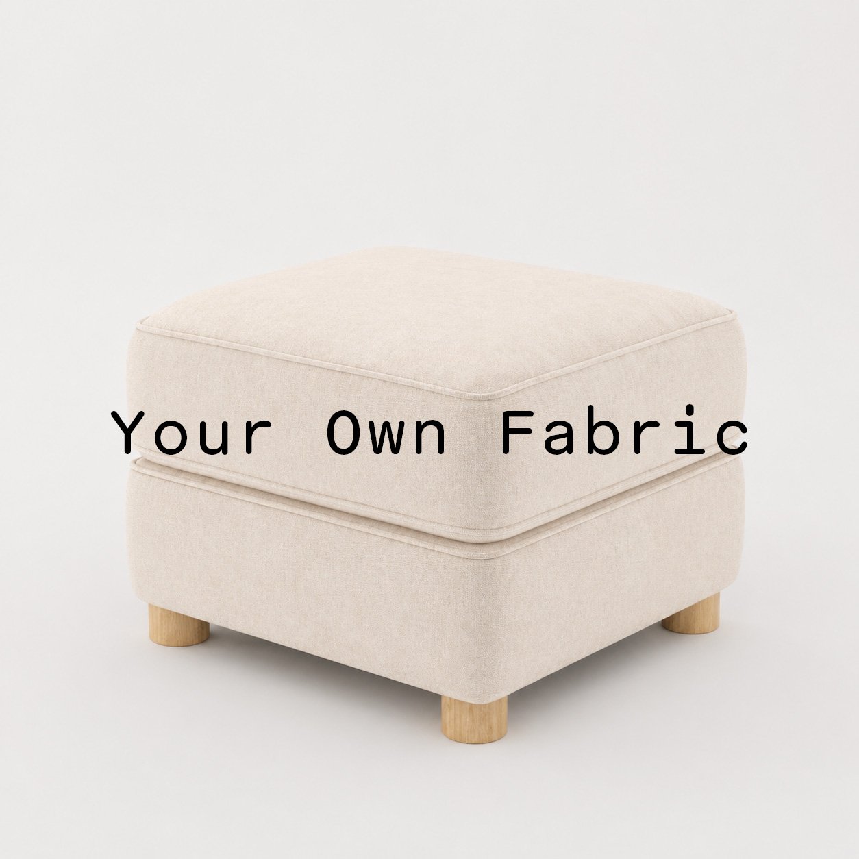 Diagonal view of the Fergus footstool upholstered in customers own material calico cotton fabric.