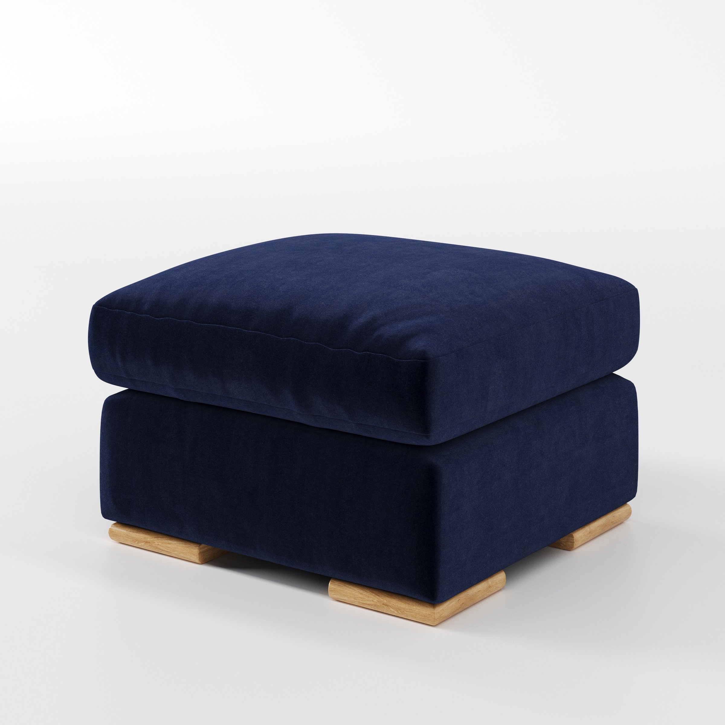 Moy footstool in Noss Velvet Navy shown at a diagonal angle highlighting deep cushioning and low wooden base.