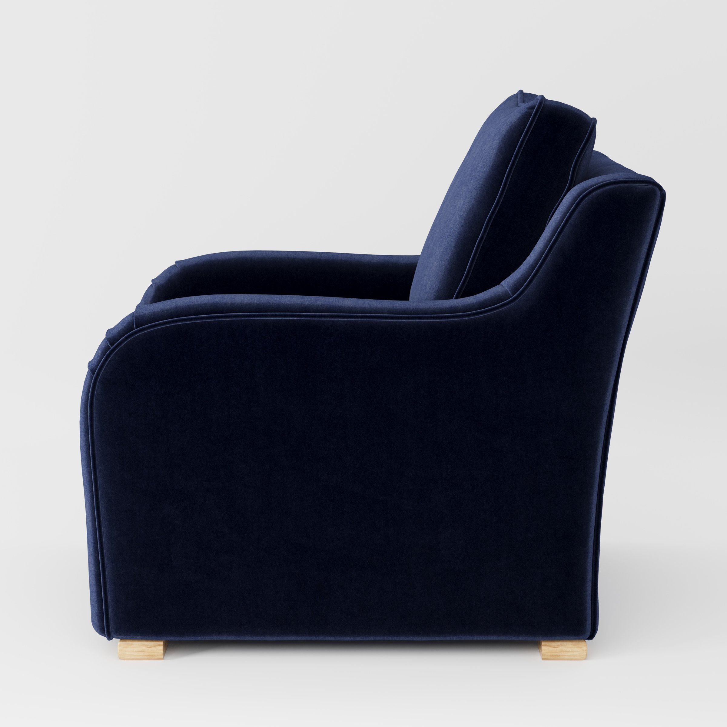 Cashel armchair in Noss Velvet Navy shown in side profile displaying proportions and overall silhouette.