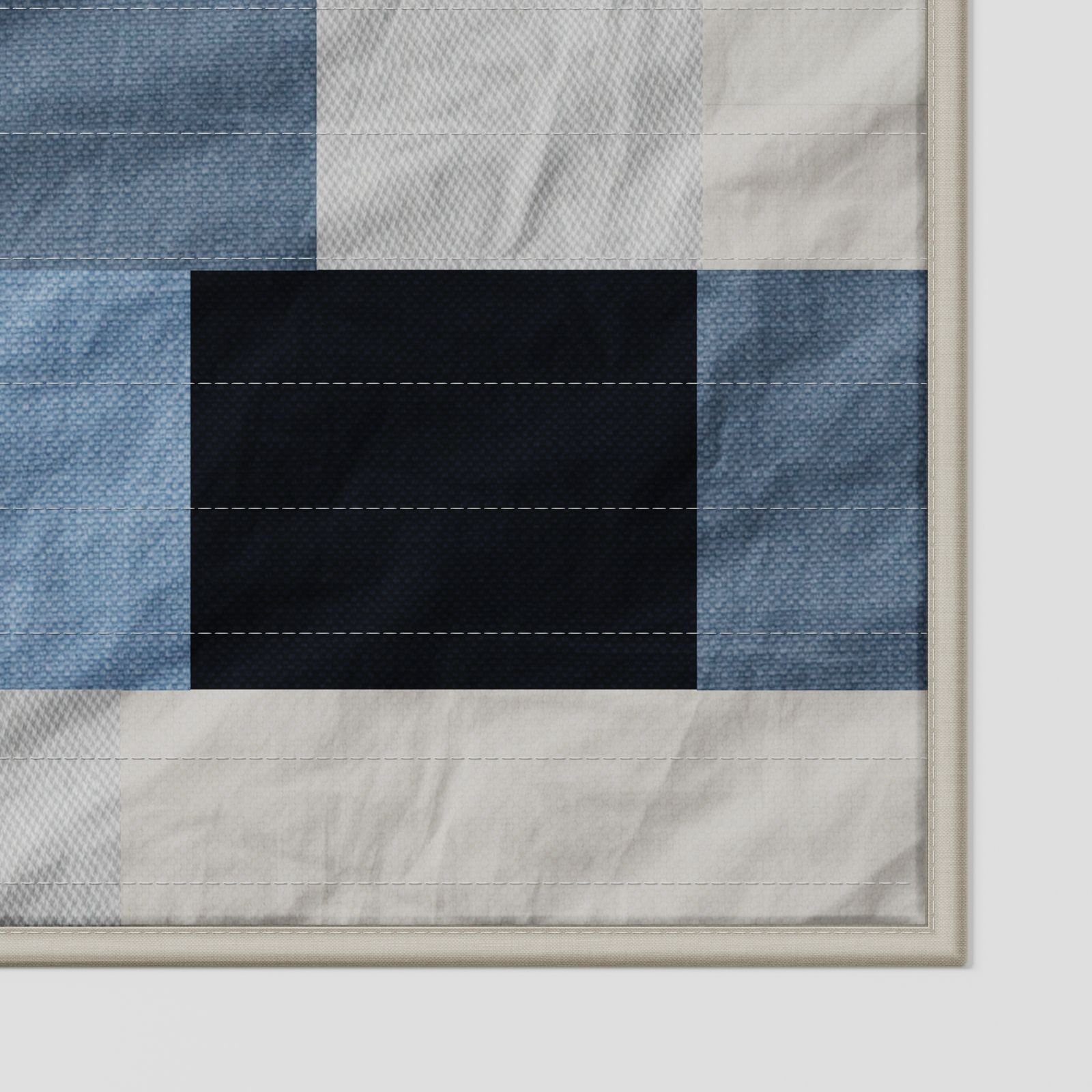 Brant patchwork quilt in soft blue, navy and off-white tones, close-up detail showing fabric texture, stitching lines and layered patchwork construction