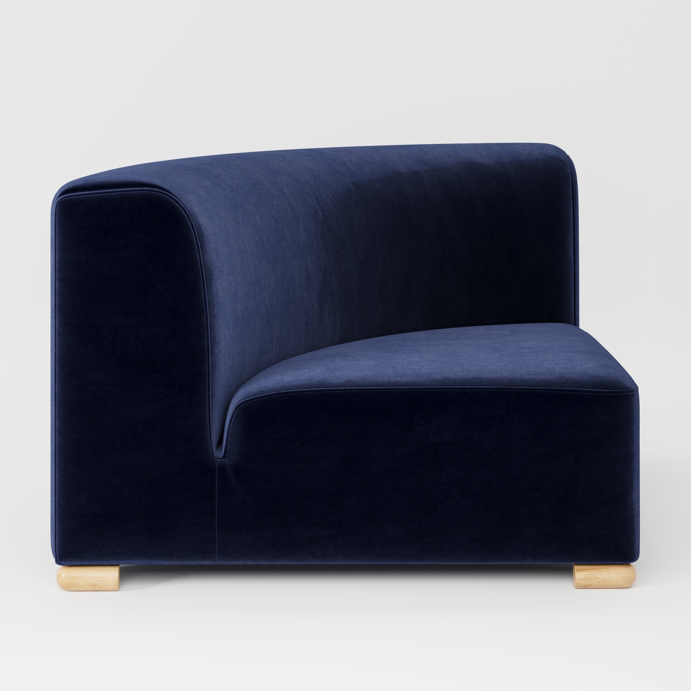 Tay corner sofa unit in Noss Velvet Navy shown from the side highlighting the curved backrest and deep seat with timber feet.