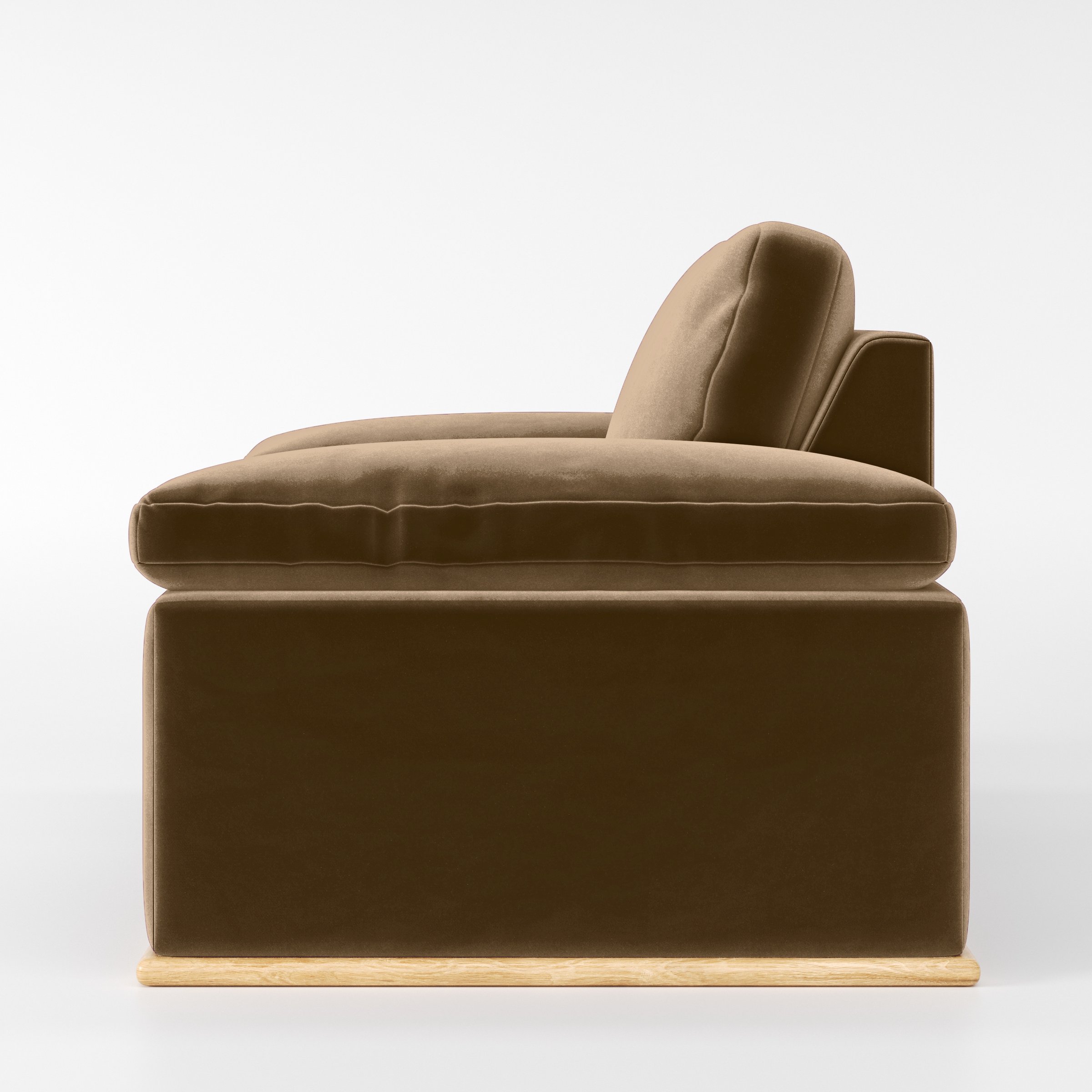 Side view of the Cusher armchair upholstered in Plush EasyClean Velvet in Caribou.