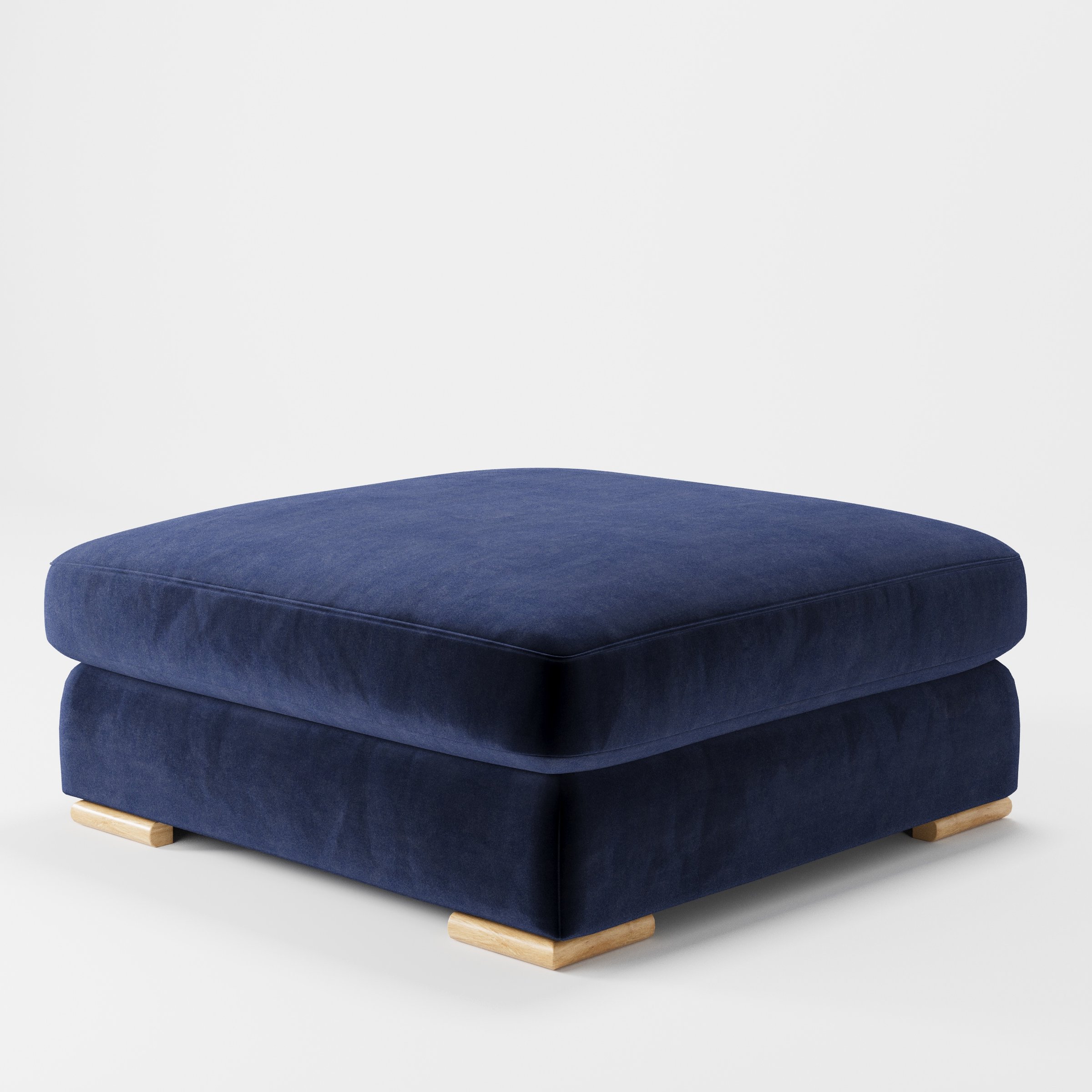 Olton footstool in Noss Velvet Navy shown at a diagonal angle highlighting low profile and inset wooden base.