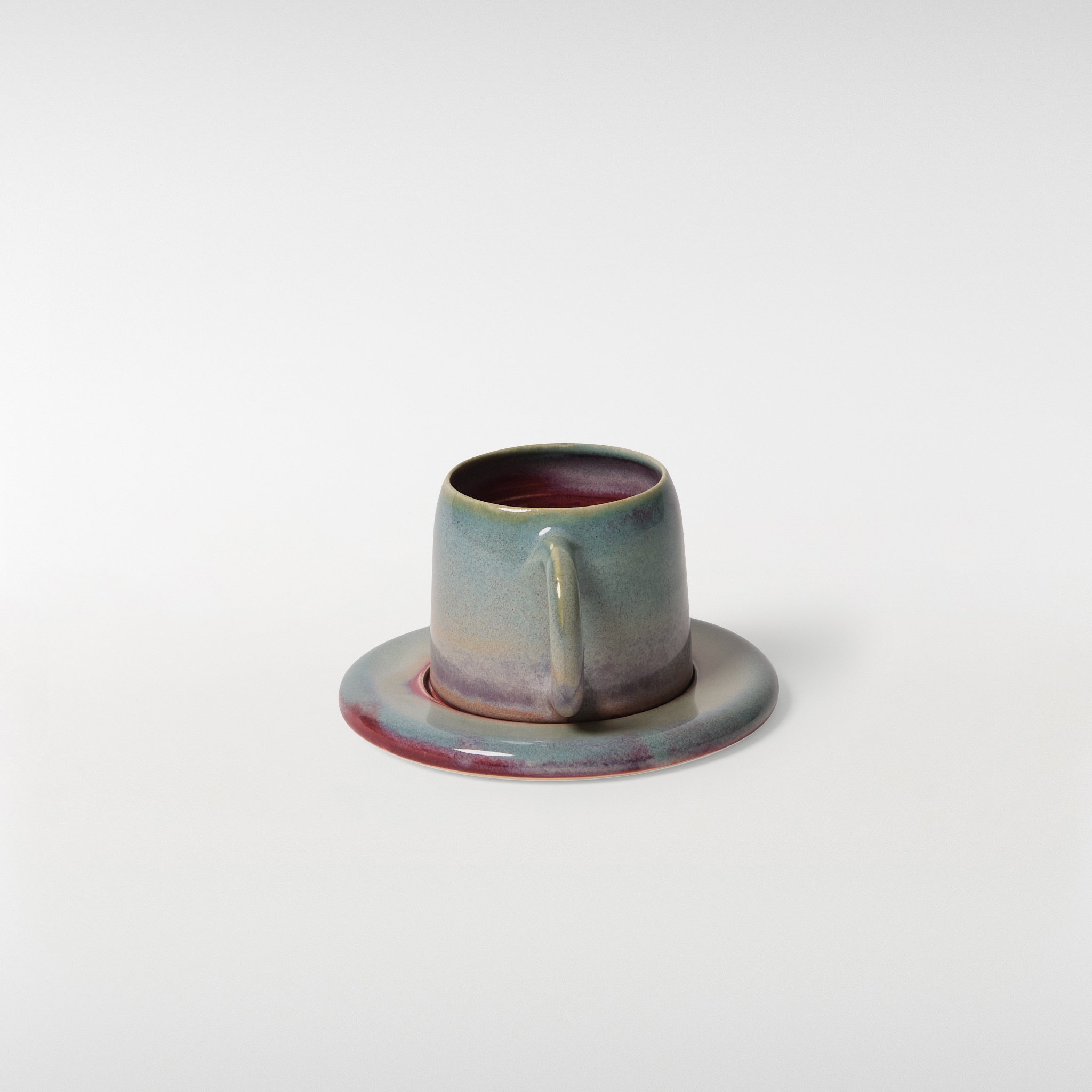 Loam glazed ceramic cup and saucer set, rear angle highlighting curved form, handle shape and soft gradient glaze
