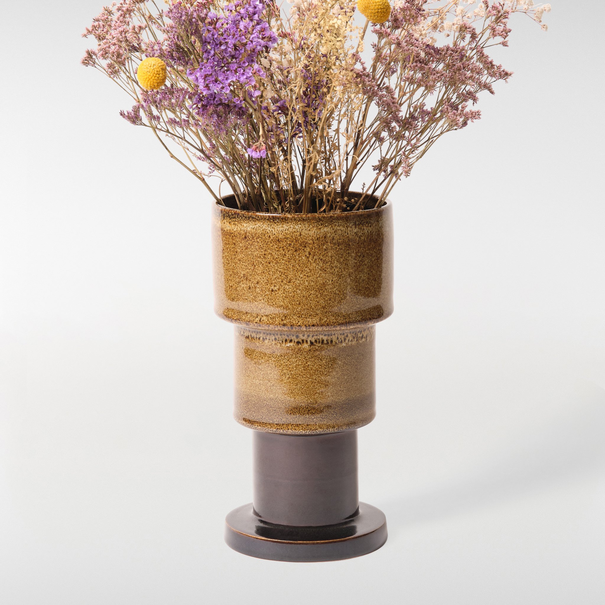 Glint Vase 1 in brown glaze with dried flowers, sculptural ceramic vase with layered cylindrical desig