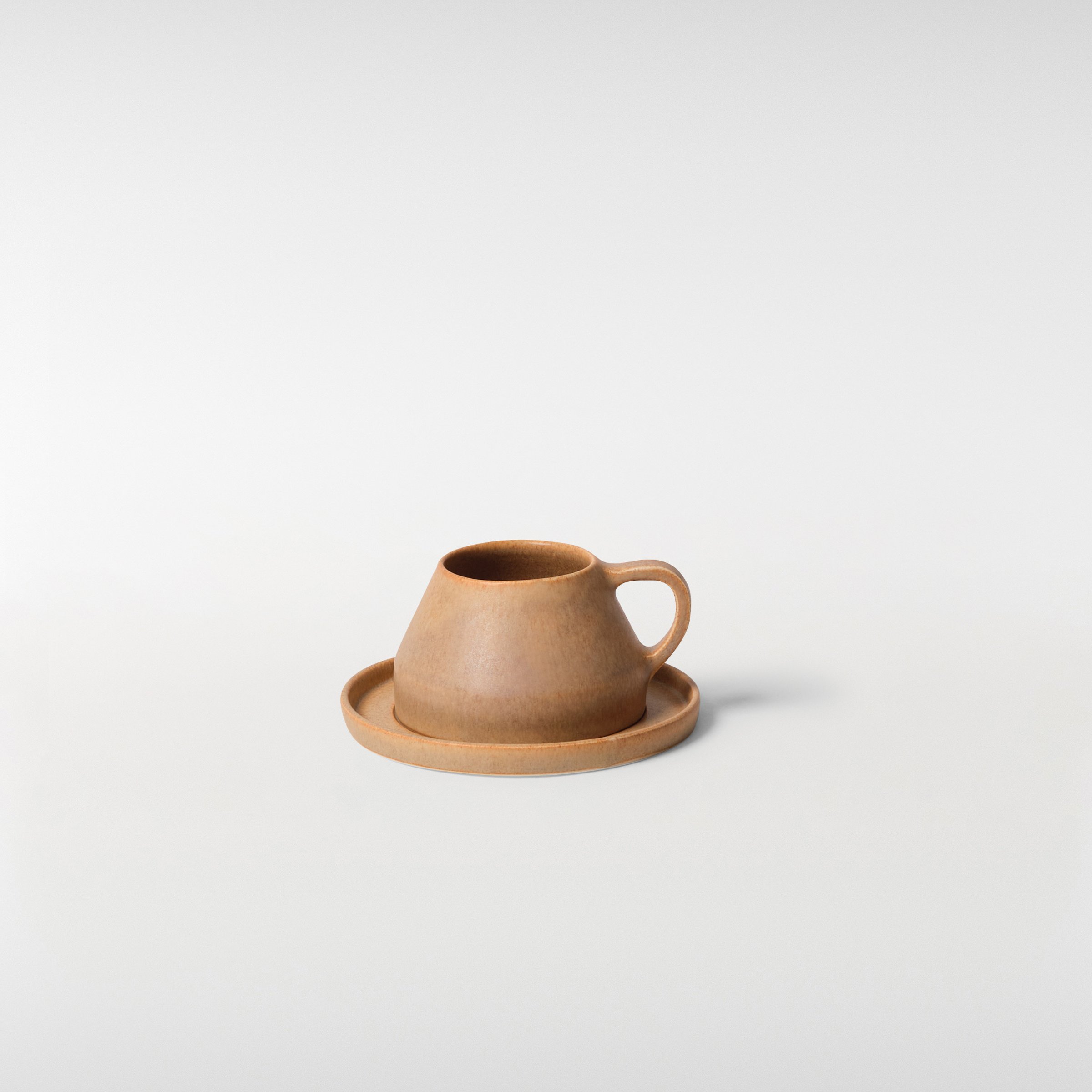 Chamfer Honey glazed ceramic cup and saucer set, front angle showing angular silhouette, single handle and warm matte finish