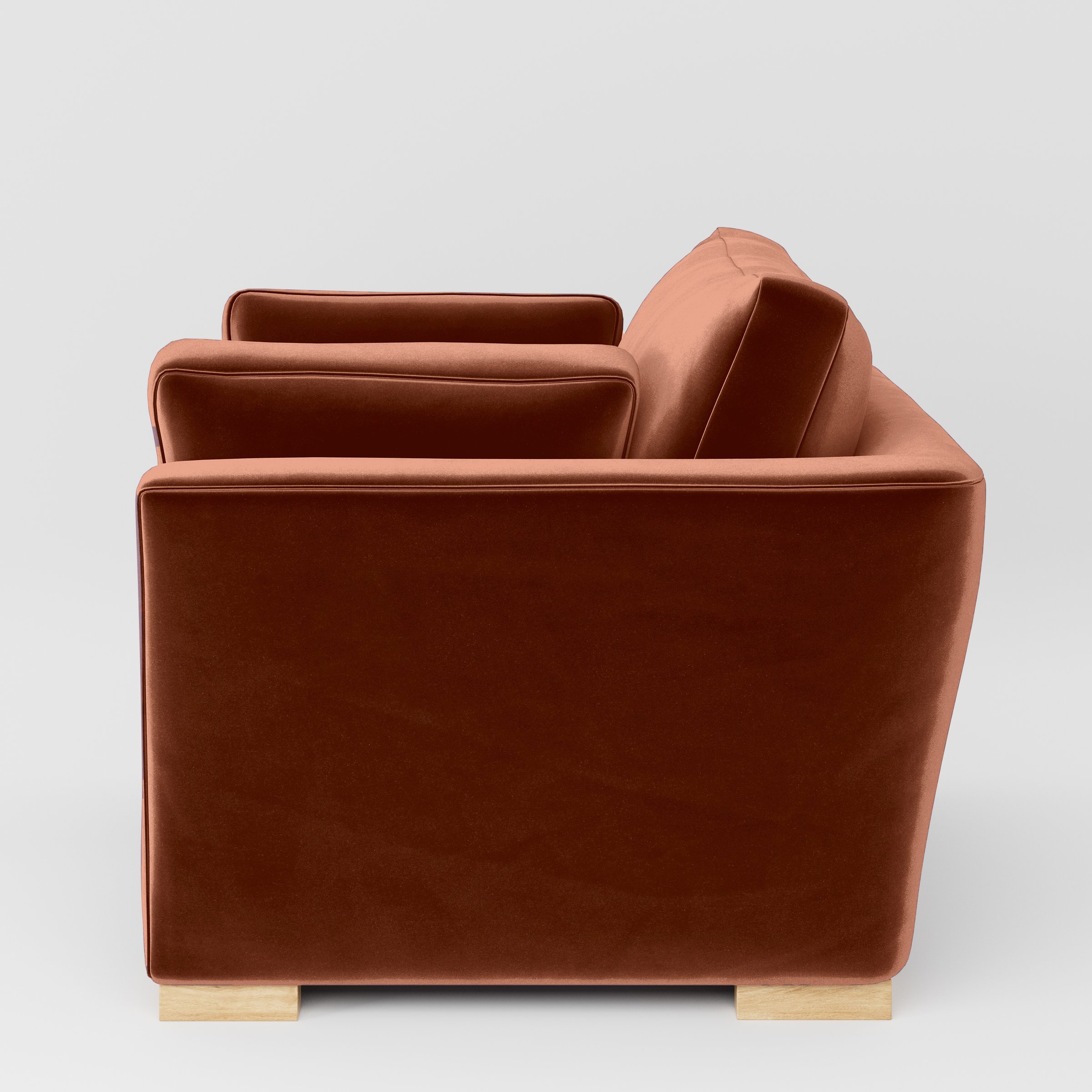 Side view of the Stowe armchair upholstered in Plush EasyClean Velvet in Apricot.