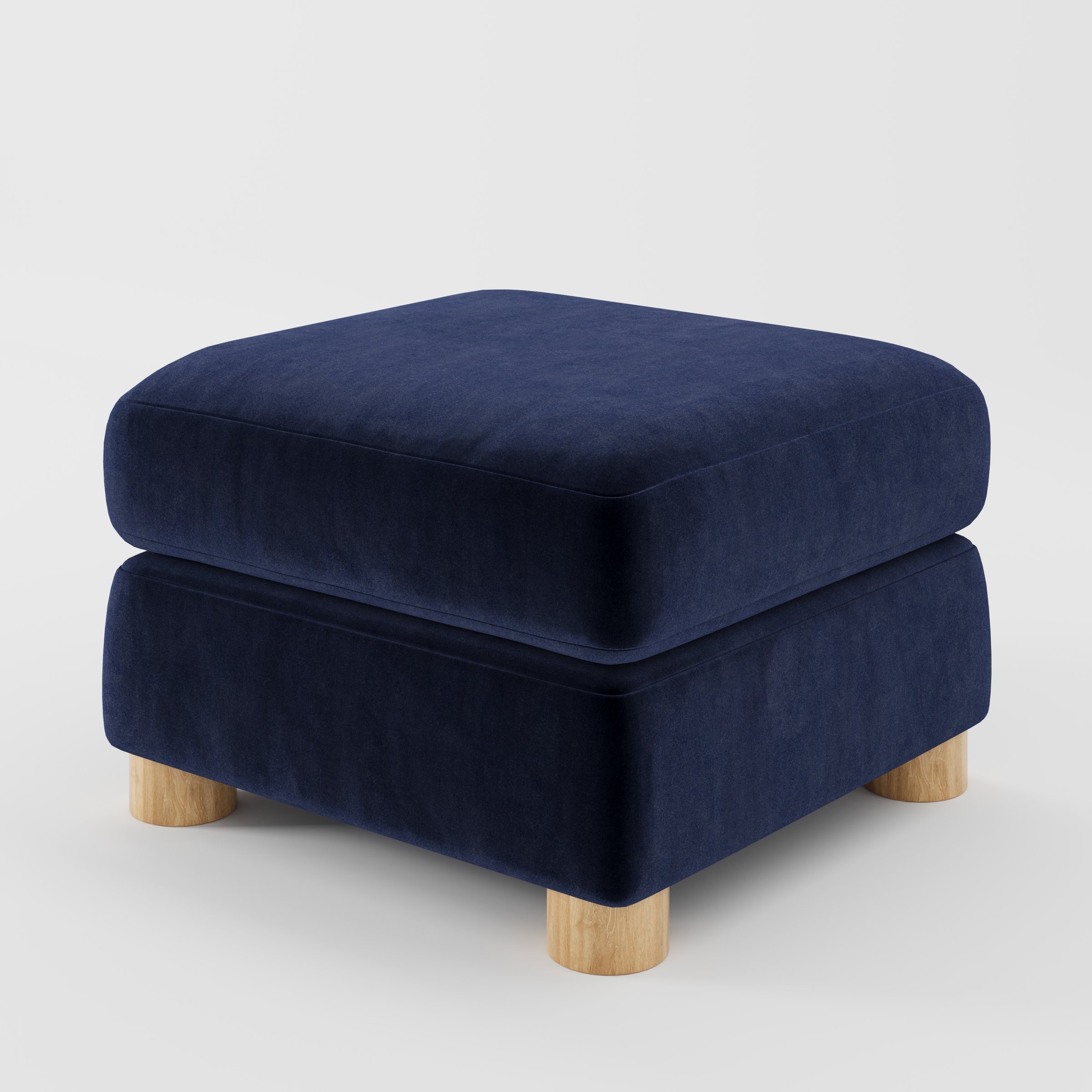 Windermere footstool in Noss Velvet Navy shown at a diagonal angle highlighting soft corners and rounded wooden feet.