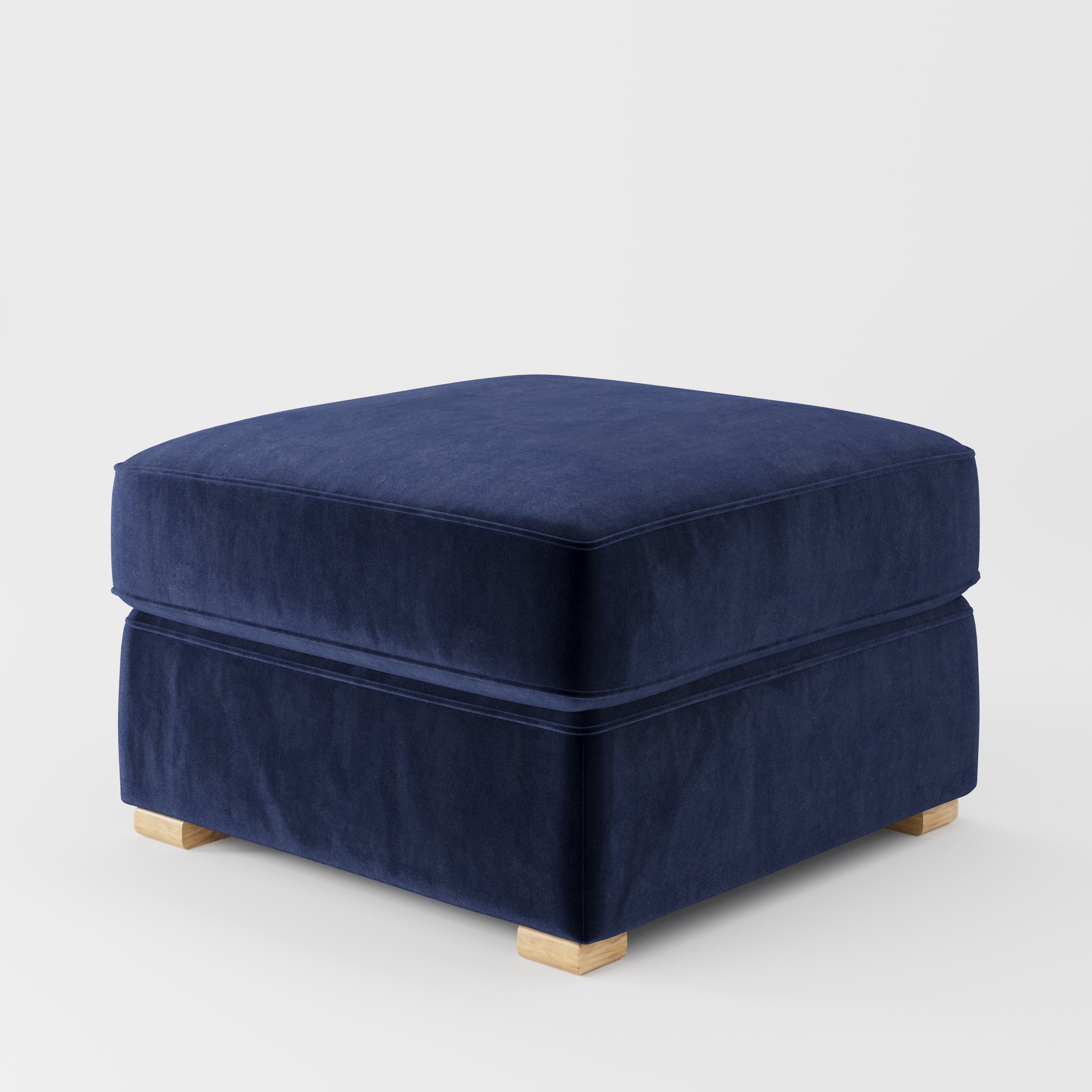 Cashel footstool in Noss Velvet Navy shown at a diagonal angle highlighting layered cushioning and low wooden feet.