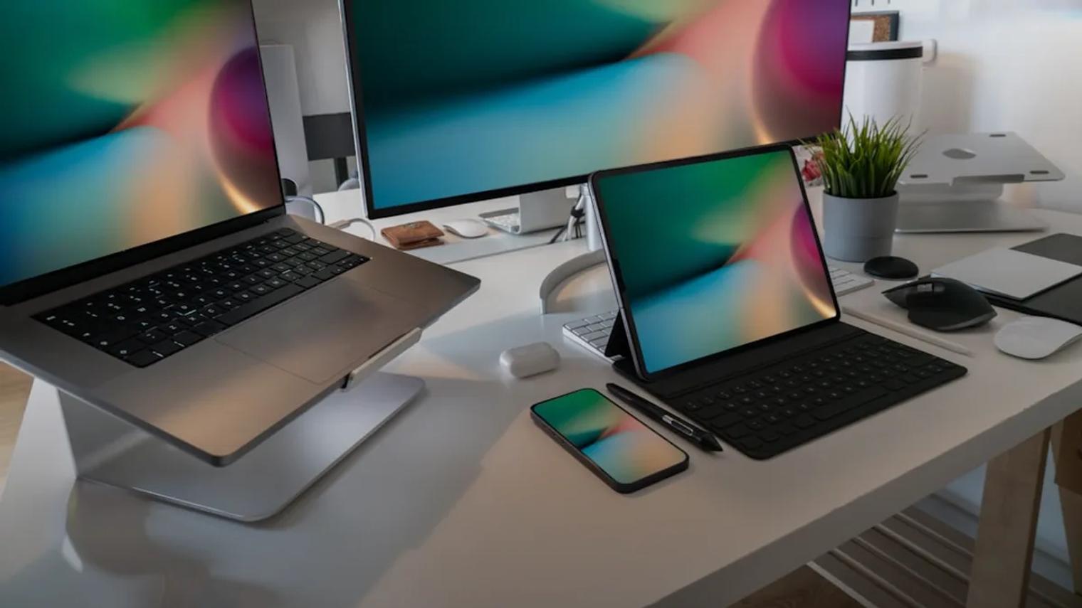 a desk with two laptops and a phone on it
