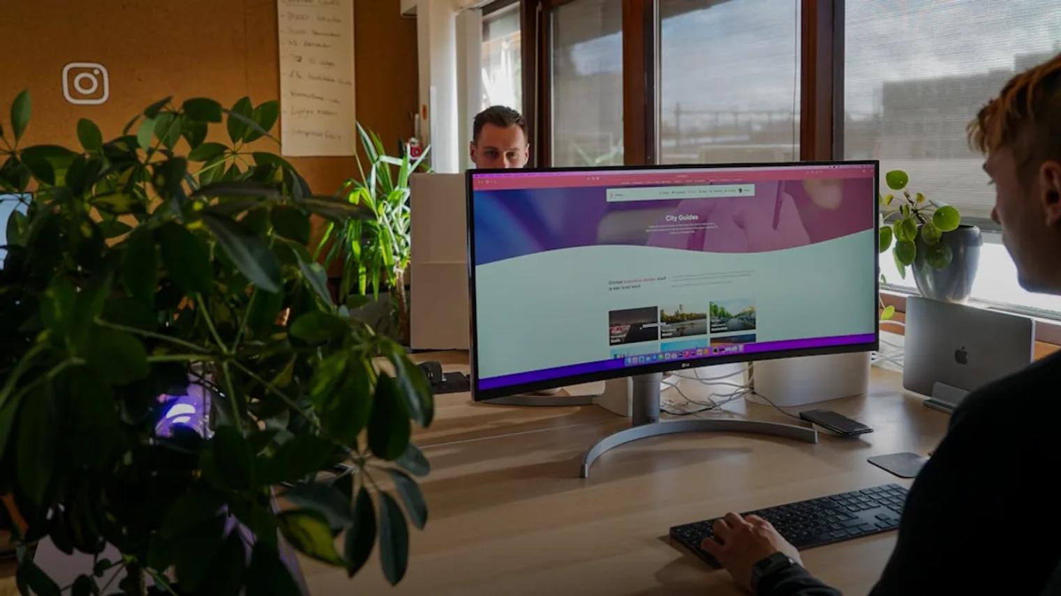a man sitting at a desk in front of a computer monitor