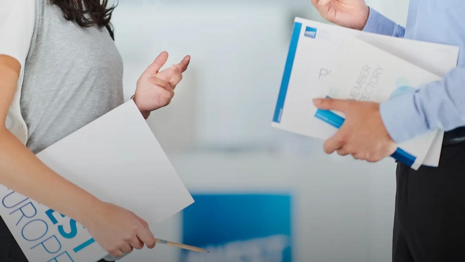 Two business professionals discussing documents in an office