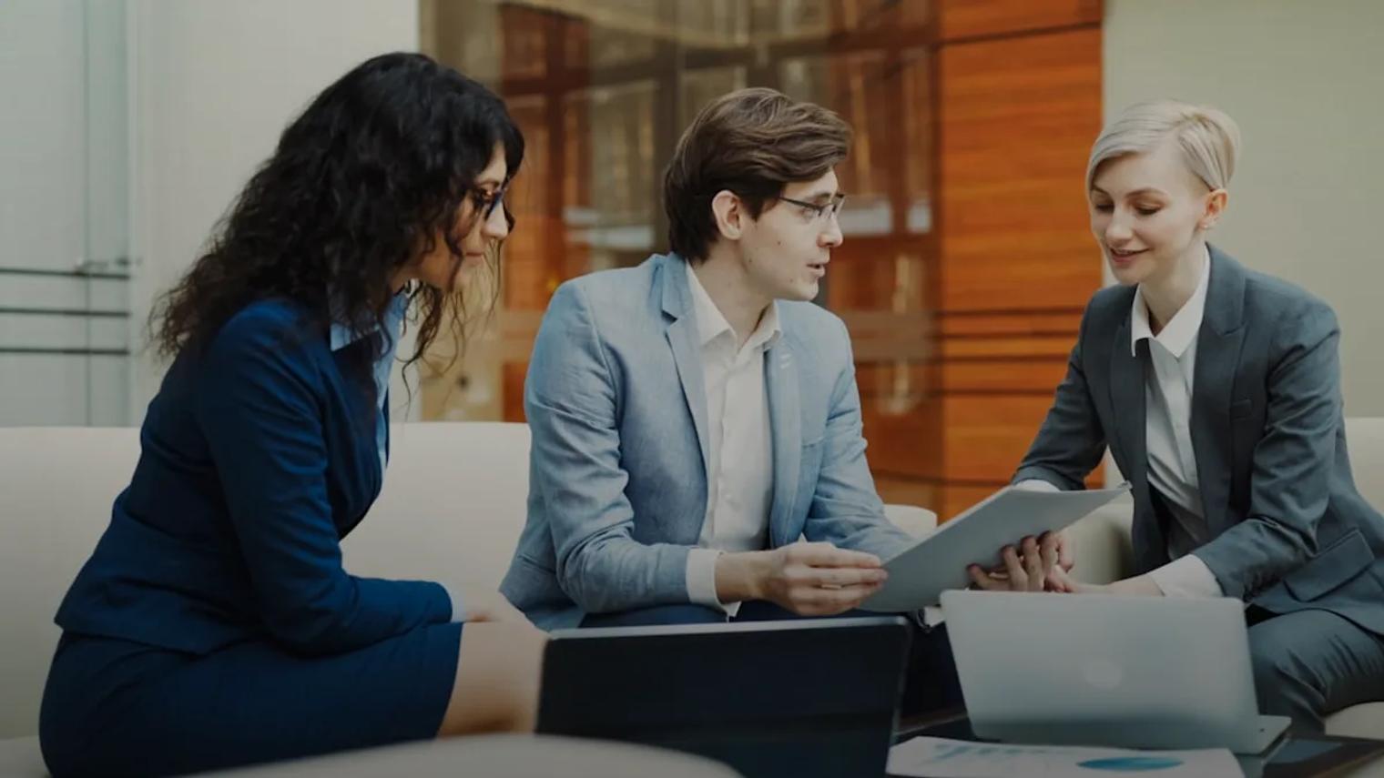 Three professionals discussing documents at a table