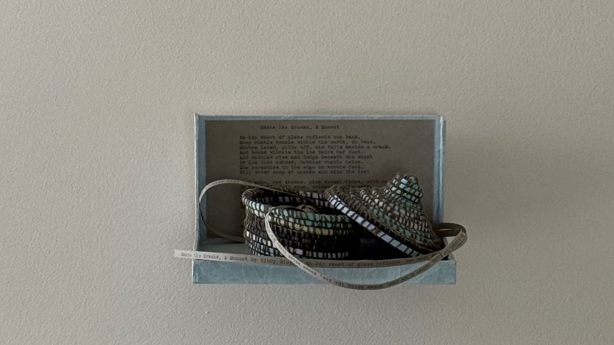 A pale blue-grey box mounted on a wall, holding a typed sonnet behind coiled woven vessels in teal, black and cream. A narrow paper strip carrying the poem's first line trails out over the lip and loops down.