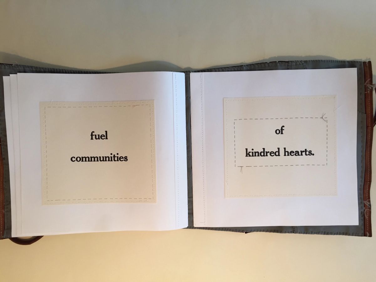 An open book with grey cloth covers. Two cream panels are stitched to white pages with dashed running stitch, each carrying letterpress-style text: "fuel communities" and "of kindred hearts."