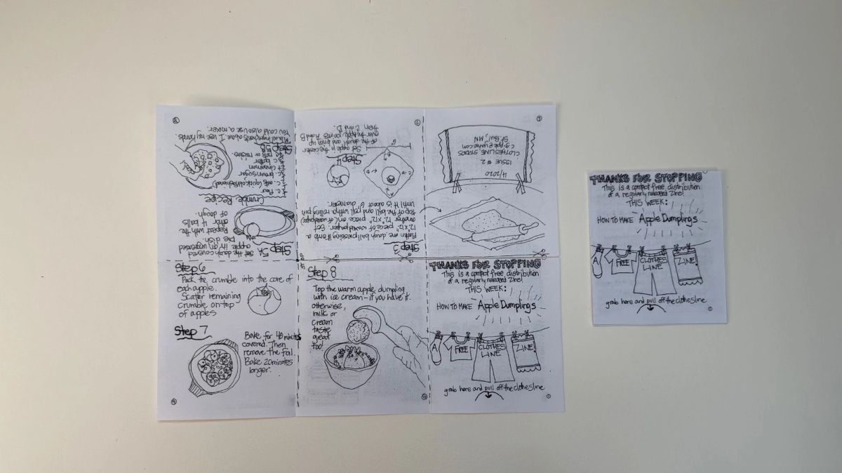 A folded eight-page zine opened flat on a wall, hand-drawn in ballpoint: a step-by-step apple dumpling recipe with small sketches of bowls and pastry. The folded cover hangs beside it.