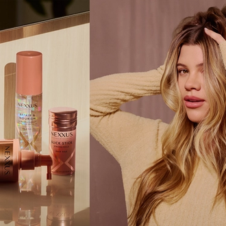 Sofia Richie Grainge poses with her hands in her hair as it cascades down in waves.