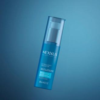 Ultralight Smooth Frizz Defy Cream Serum is shown against a blue background.