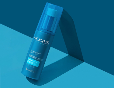 Ultralight Smooth Frizz Defy Cream Serum is shown against a blue background.