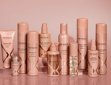 The entire Nexxus Styling Line collection is shown against a shiny, rose-gold background.