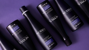 Bottles of Keraphix Keratin Shampoo and Keraphix Keratain Conditioner are shown lined up, lying on a purple surface.