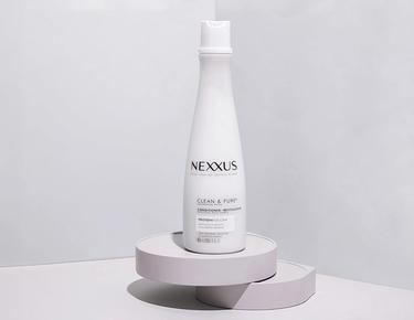 The Nexxus Clean & Pure Conditioner is shown standing against a white marble background.
