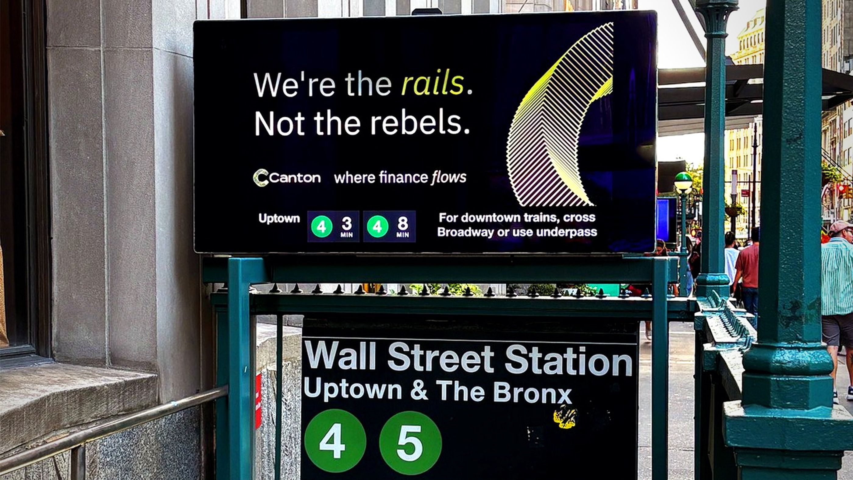 Canton advertisement reading "We're the rails. Not the rebels." above the Wall Street subway entrance