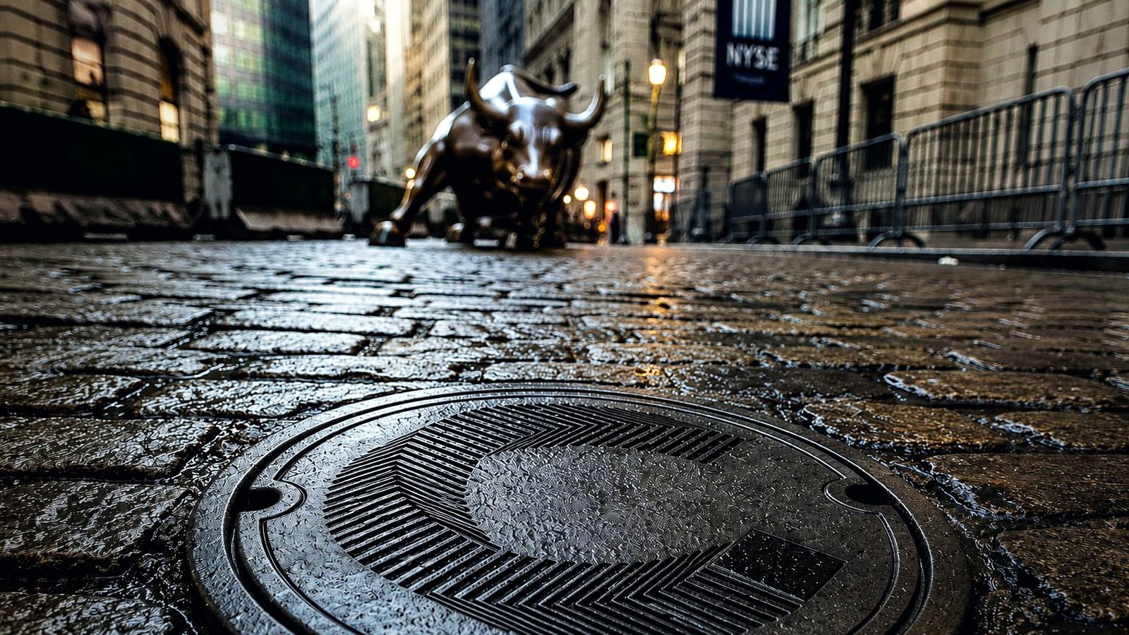 Wall Street bull statue behind a Canton-branded manhole cover on a wet cobbled street in New York