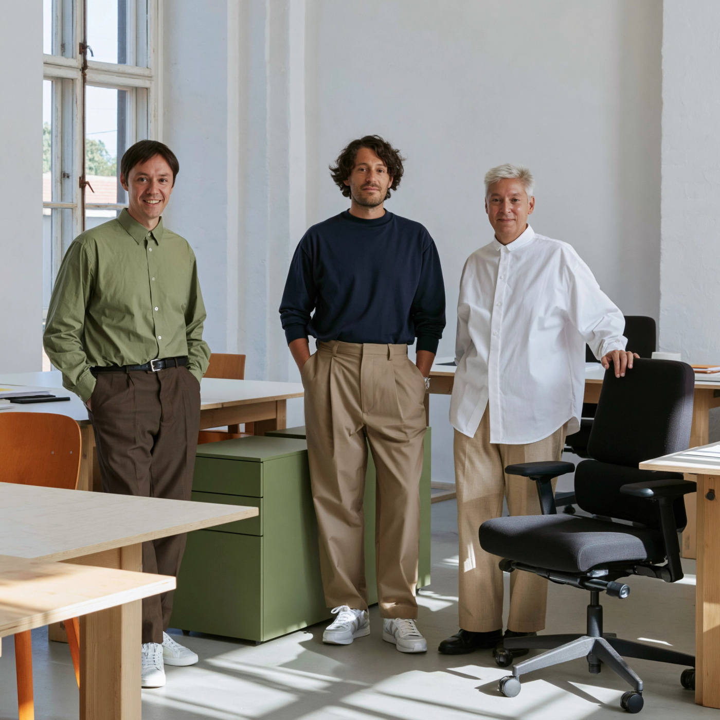 Three people standi in a circular office