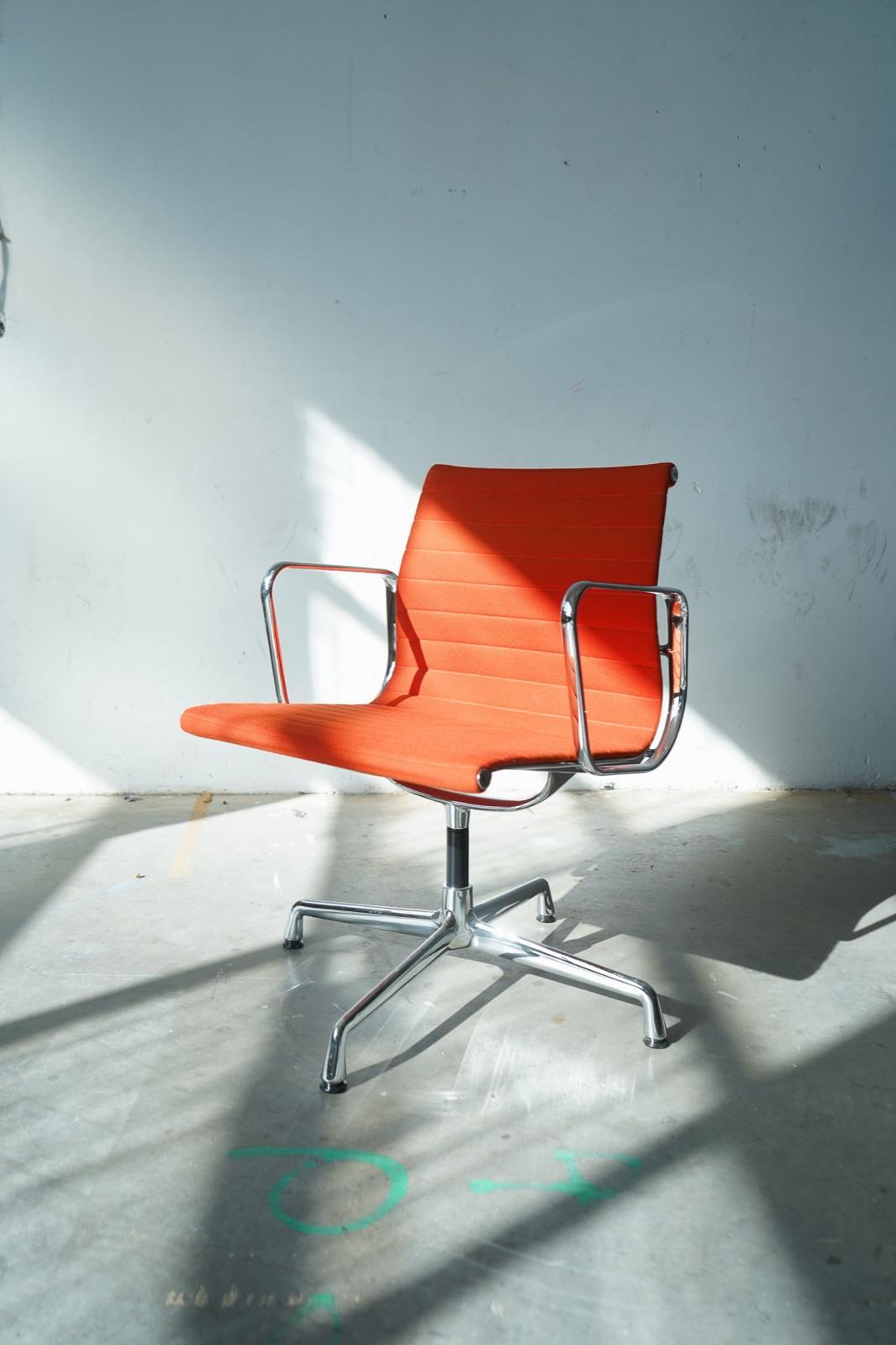 A reused orange office chair against a plain wall