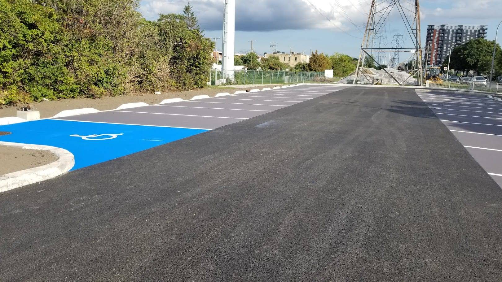 Parking lot line marking installation in Canada: stall layout and accessible parking at a multi-level parking deck approach