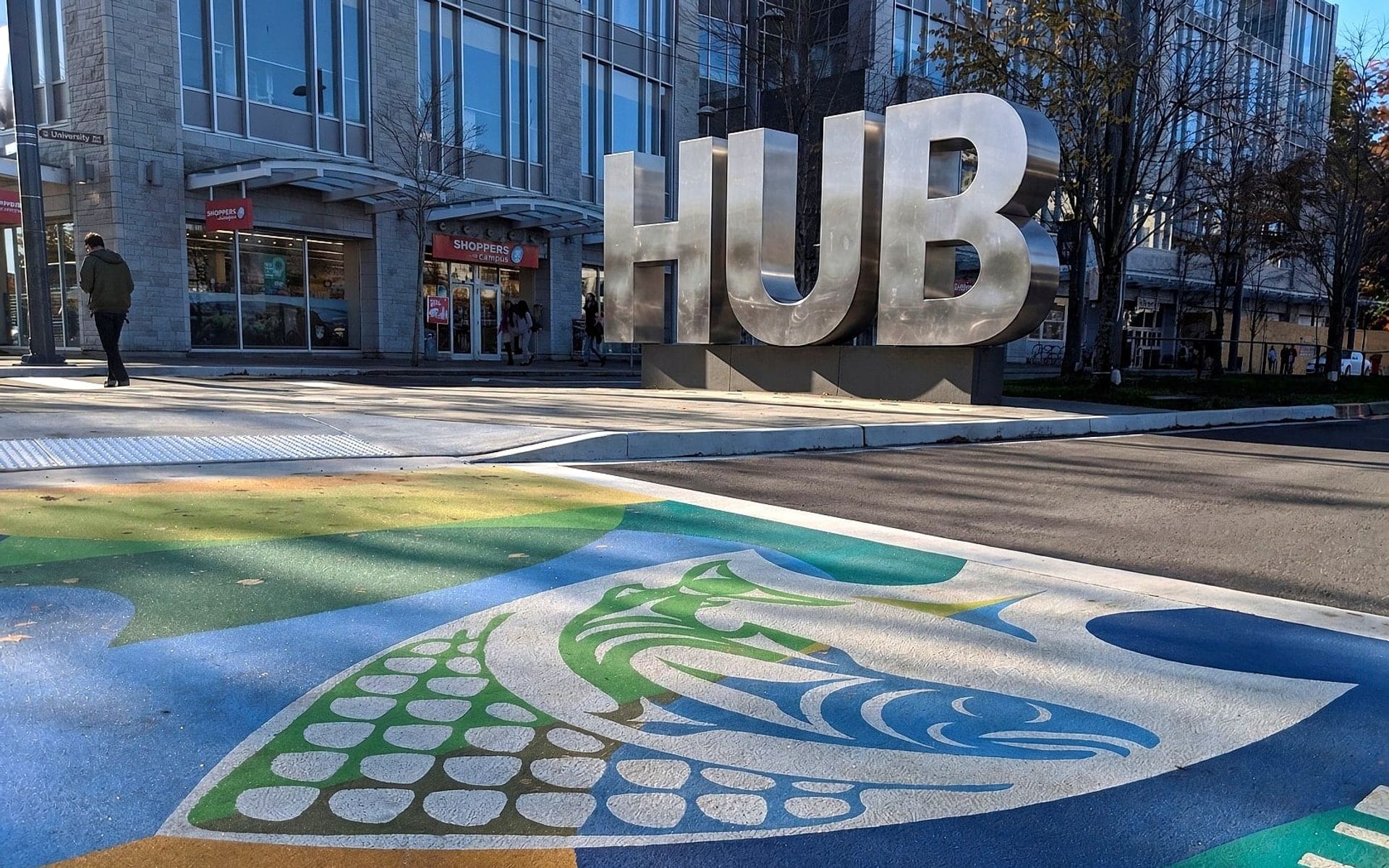 The UBC Musqueam crosswalk at the University of British Columbia campus entrance in Vancouver: Coast Salish artwork rendered in coloured pavement by HUB Surface Systems