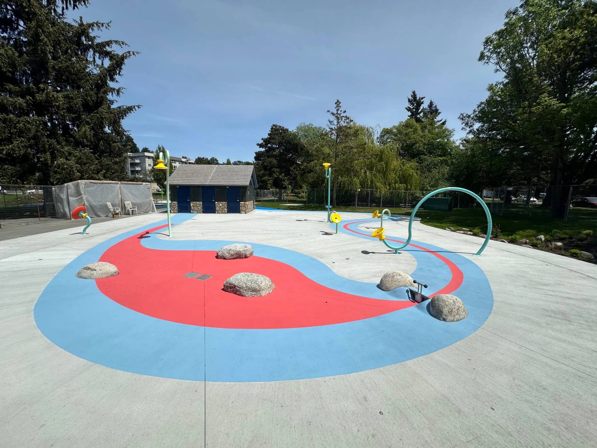 Splash pad surfacing in slip-resistant coloured surface coating at a community water play area, Canada